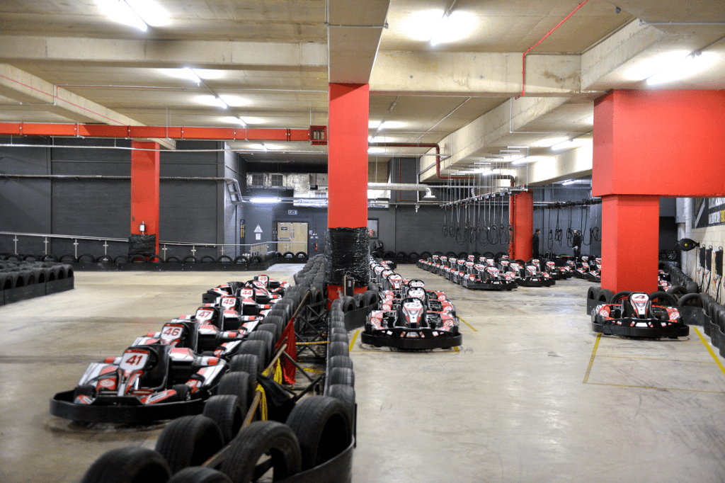 Underground go karting track with rows of go karts lined up.