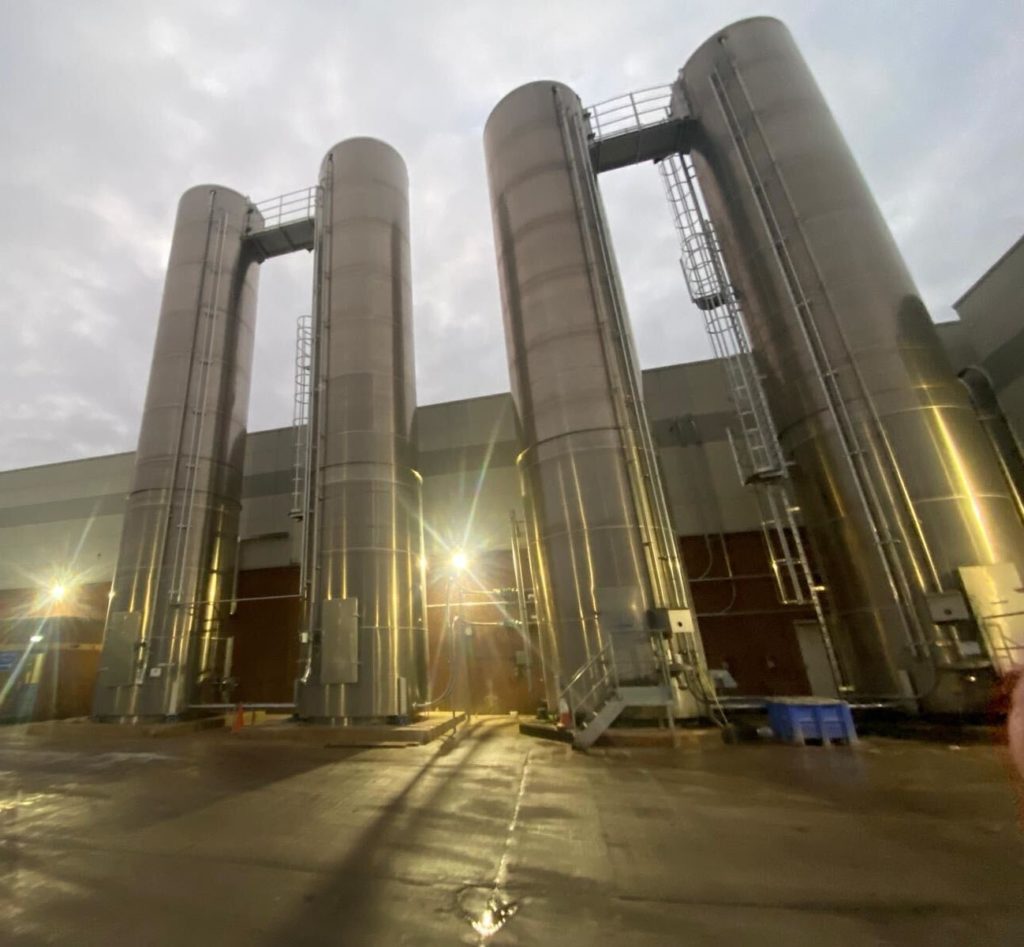 Exterior view of manufacturing plant in Coventry featuring four tall metal towers reflecting the sunlight.