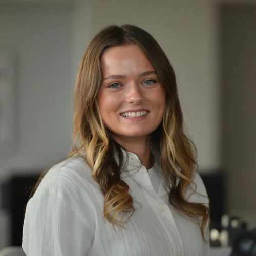 Headshot of Georgia smiling. She is wearing a white blouse.