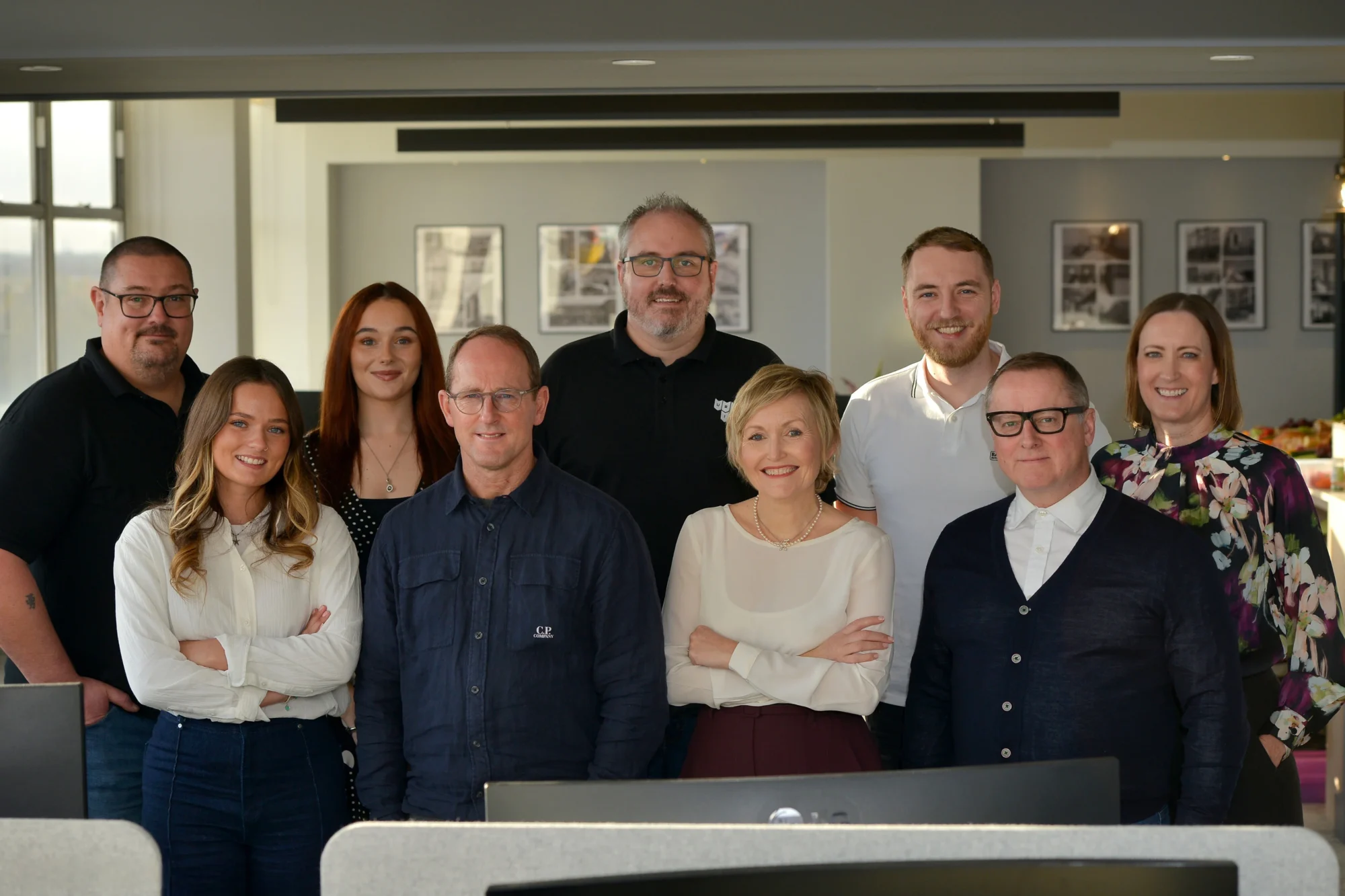 The Urbanise team together in the office, smiling at the camera.